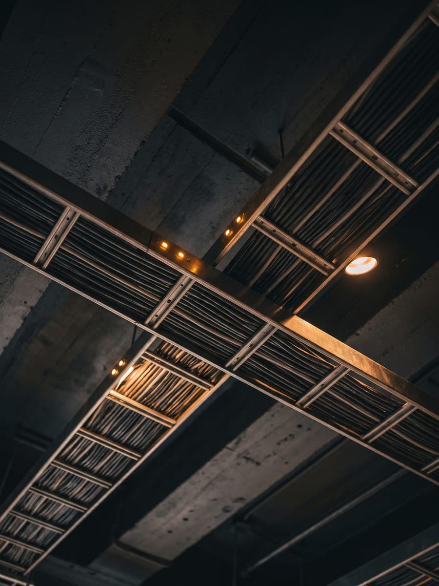 Kabeltrassen unter einer dunklen Decke, Bündel in geraden Linien